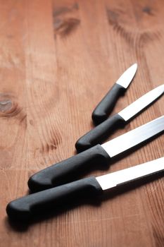 Kitchen knives set in a row on wooden surface