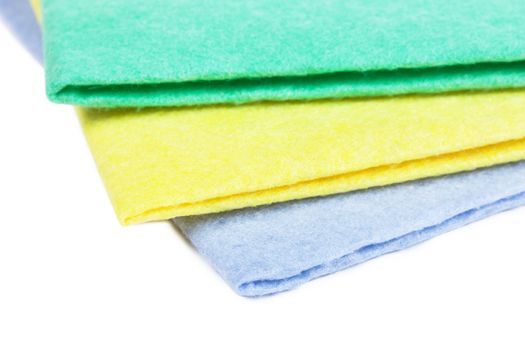 Three kitchen napkins yellow, blue and green over white background