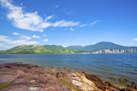 Sea coast landscape with Sha Tau Kok village background in Hong Kong Geo Park. 