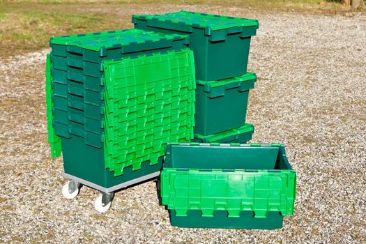 Stack of green plastic tote attached lid boxes