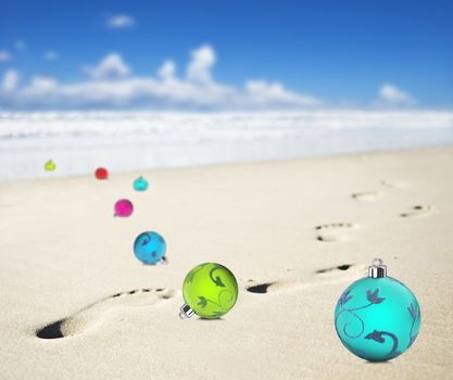 Christmas baubles on a beach with footprints