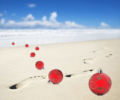 Christmas baubles on a beach with footprints