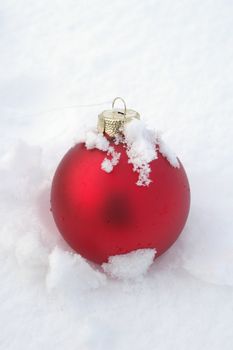 a red bauble in snowy winter landscape