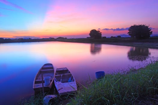 Isolated boats along the pond at sunset time