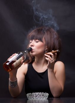 photo of woman drinks alcohol and smokes a cigar