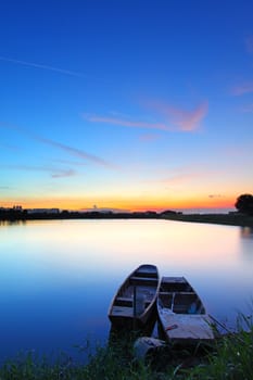 Sunset along the pond with two boats