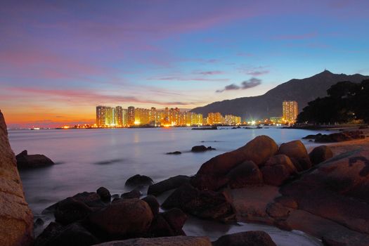 Sunset along seashore with long exposure of sea stones