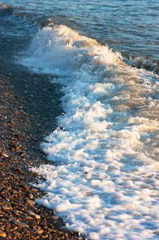 A wave on empty beach in summertime