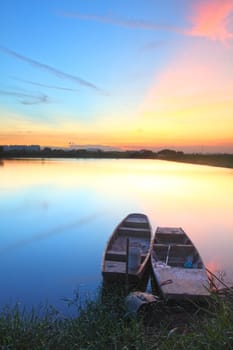 Sunset with isolated boats in water body