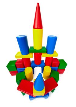 Toy castle made ​​of multicolored plastic blocks isolated on white background