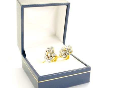 Diamond earrings on yellow gold, isolated in a blue and white gift box towards white background