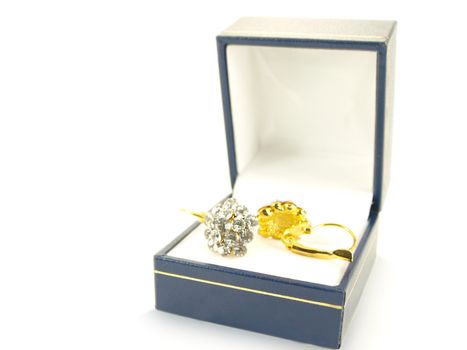 Diamond earrings on yellow gold, isolated in a blue and white gift box towards white background