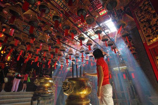 HONG KONG - 26 Jul, Man Mo temple in Hong Kong with many incense coils and tourists on 26 July, 2011. It is a very famous temple in Hong Kong for the worship of the civil or literature god Man Tai. It was graded as a Grade I historic building in 1993 and it is now a declared monument.