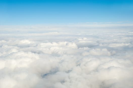 White clouds taken form above while flying in a plane.