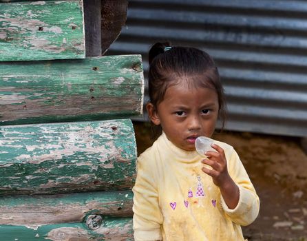 A Poor Nepali Girl child looking with doubt in her mind