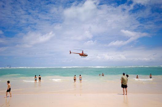 A helicopter is flying very near the beach. Dominican Republic, Punta Cana.