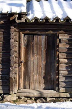 Old wooden door with snowy roof