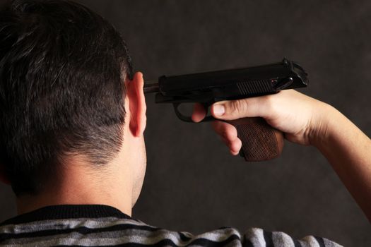 The man with a pistol on a dark background 