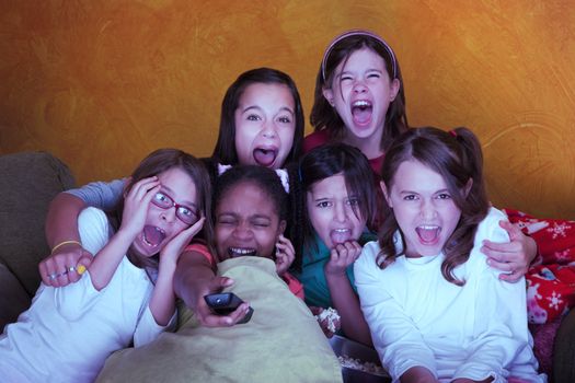 Six girls watching a movie scream at a sleepover