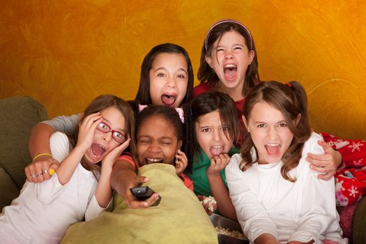 Six girls watching a movie scream at a sleepover