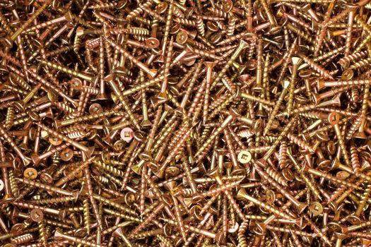 Heap of coated steel deck screws close up