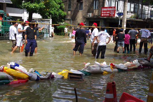 BANGKOK - OCT 30: Unidentified residents of Bangkok's Samsen road  Dusit district make their way through flooded streets after the Chao Phraya River bursts its banks on Oct 30, 2011 in Bangkok, Thailand.