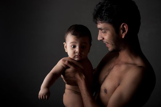 Indian father and son in happy pose over black background