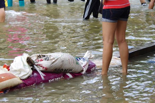 BANGKOK - OCT 30: Unidentified residents of Bangkok's Samsen road  Dusit district make their way through flooded streets after the Chao Phraya River bursts its banks on Oct 30, 2011 in Bangkok, Thailand.