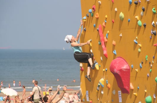 Annual Bouldering Competition on Scheveningen beach. Participants climbing artificial rock face.