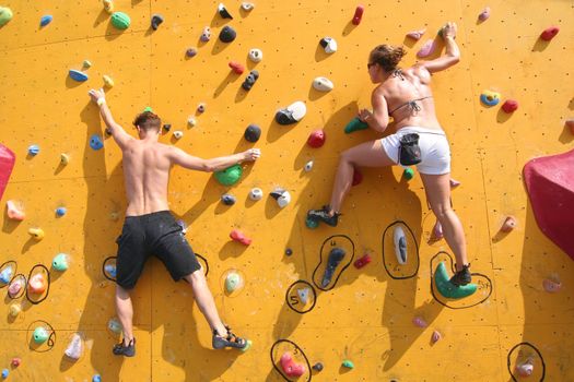 Annual Bouldering Competition on Scheveningen beach. Participants climbing artificial rock face.