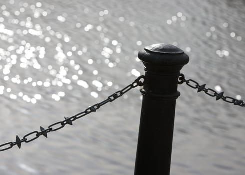 Steel bollard and chain by the water