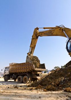 The dredge and the dumper truck work on building.