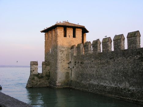Castello Scaligero, built inside Lake Garda, at sunset