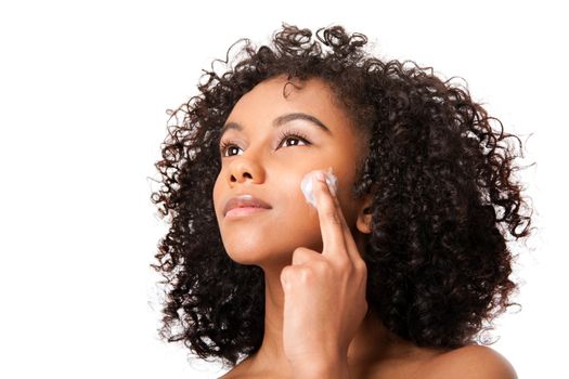 Beautiful young Brazilian woman applying massaging exfoliating anti-aging cream facial mask - skincare cosmetology - isolated.
