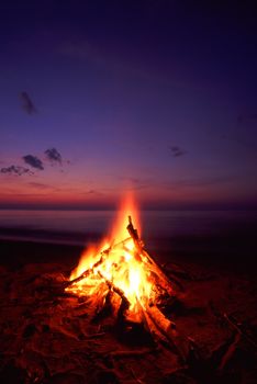 Blazing campfire at sunset along the beautiful beach of Lake Superior in northern Michigan.