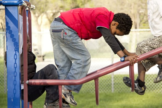 young kids playing at the playground climbing on a metal structure