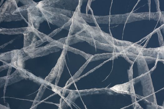 Network of cracks in thick solid layer of ice of a frozen lake due to stress caused by temperature changes.