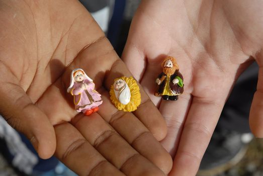 hands of two children with Christmas figurines