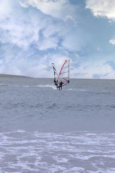 two surfers windsurfing in the maharees in county kerry ireland during a storm coming close to each other making the shape of a butterfly