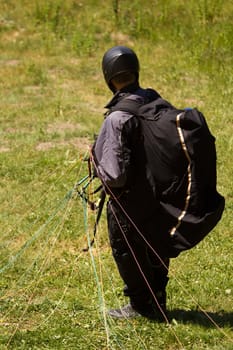 A Paraglider flying from a mountain on a warm summer afternoon