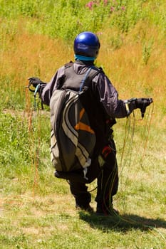 A Paraglider flying from a mountain on a warm summer afternoon