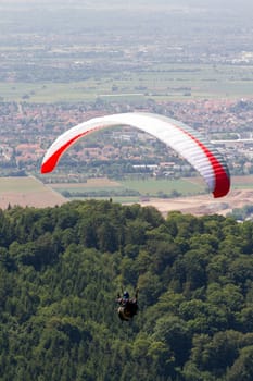 A Paraglider flying from a mountain on a warm summer afternoon