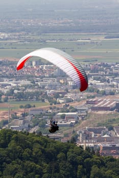 A Paraglider flying from a mountain on a warm summer afternoon