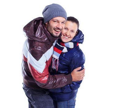 Young happy couple dressed in winter clothes. In the studio