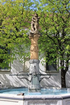 Famous historical fountain of Samson in Fribourg, Switzerland, surrounded by trees