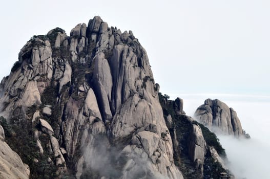 Landscape of rocky mountain peaks in a foggy morning