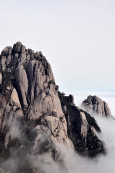Landscape of rocky mountain peaks in a foggy morning