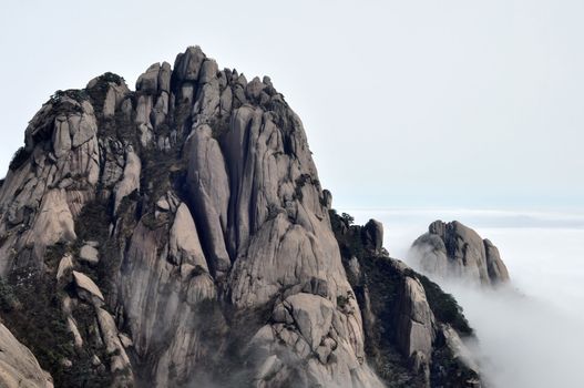 Landscape of rocky mountain peaks in a foggy morning
