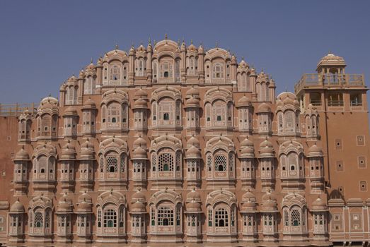 Hawa Mahal or Palace of the Winds. Ornate pink facade built to allow ladies of the Royal Court to look into the street without being seen. Jaipur, Rajasthan, India