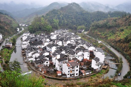 Landscape of a traditional Chinese village surrounded by a river and mountains